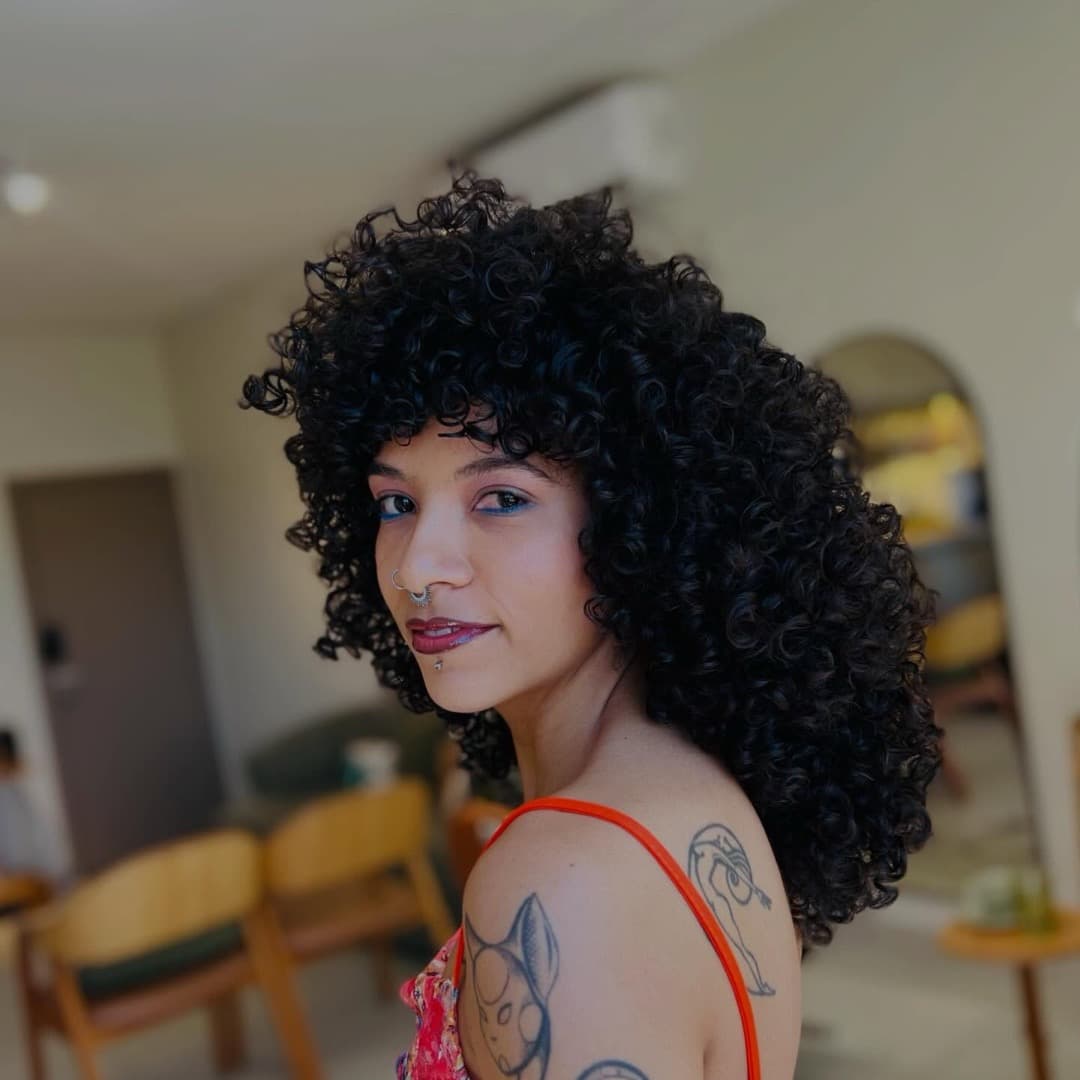 Cliente do Studio Raízes com cachos volumosos e definidos